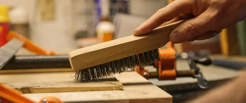 Cepillo de alambre con armazón de madera empleado en proyecto de carpintería
