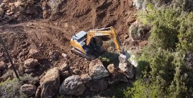 Máquina despejando el terreno para una construcción - Naves industriales