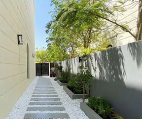 Casa con sendero, jardineras y cerca perimetral