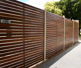 Cerca perimetral de madera con postes de concreto